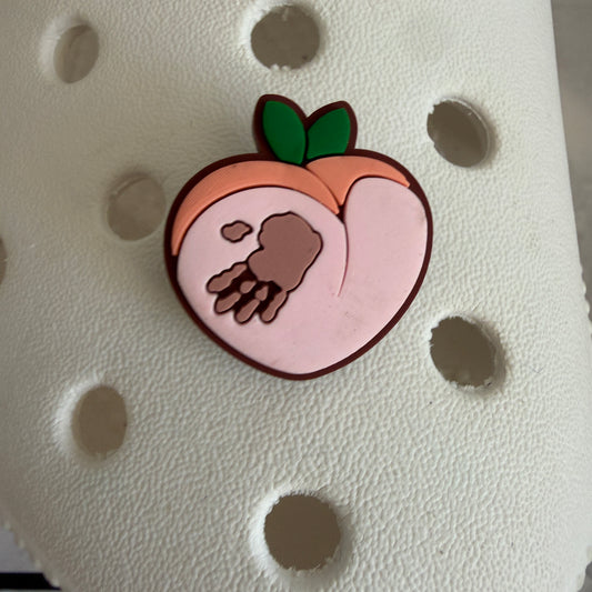 Hand on peach shoe charm